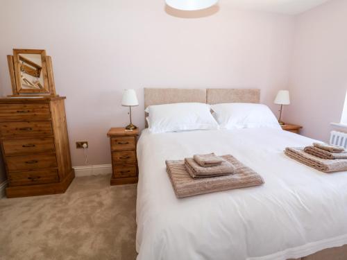 a bedroom with a white bed with towels on it at Keepers Cottage in York