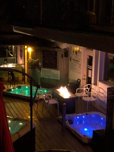 a patio with a hot tub and a table and chairs at Auberge Hotel Spa Watel in Sainte-Agathe-des-Monts