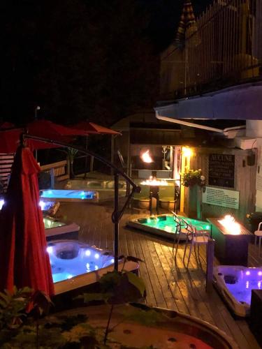 a swimming pool with lights on a deck at night at Auberge Hotel Spa Watel in Sainte-Agathe-des-Monts