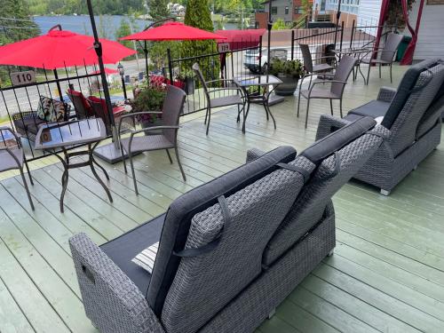 a group of chairs and tables and umbrellas on a deck at Auberge Hotel Spa Watel in Sainte-Agathe-des-Monts