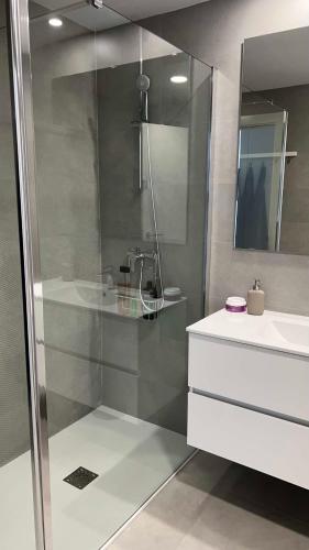a bathroom with a shower with a sink and a mirror at Rincón Idilia (Málaga). in Rincón de la Victoria