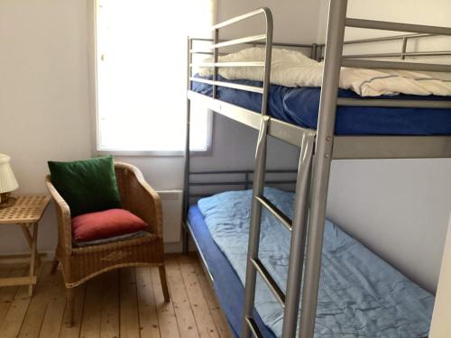 een slaapkamer met 2 stapelbedden en een stoel bij Holiday home Olofström IV in Olofström