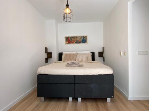 1 dormitorio con 1 cama en una habitación con paredes blancas en Hotelkamer Prinsenstraat with Free Parking en Groningen