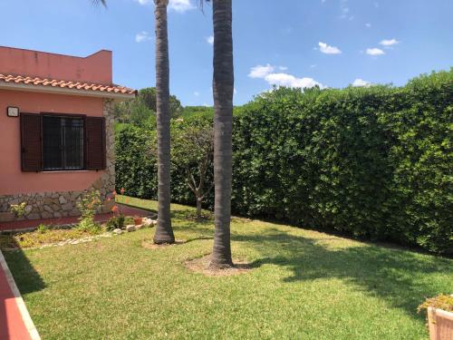 un patio con dos palmeras y una casa en VILLA MICHELA, en Plemmirio