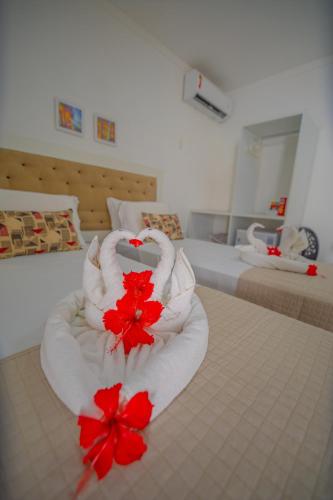 a hotel room with a stack of towels on a bed at Pousada Polymar in Maragogi