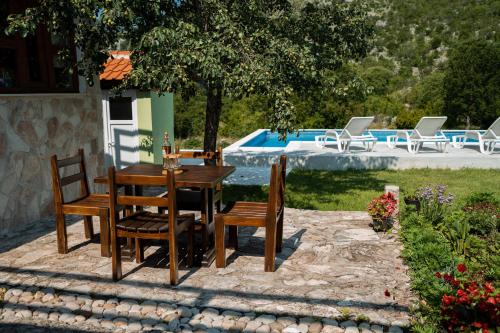 內烏姆的住宿－Villa Mramor，一张木桌和椅子,旁边是游泳池