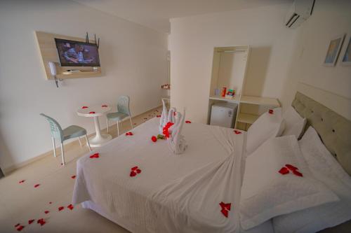 Un dormitorio con una cama con flores rojas. en Pousada Polymar, en Maragogi
