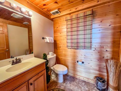 斯旺顿Lake Access Hot Tub Fire Pit Free Golf More的浴室里有马桶、洗手池和镜子。