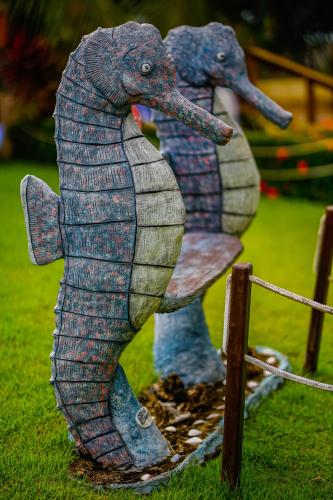 two statues of elephants sitting on a fence at Pousada Polymar in Maragogi