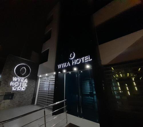 a hotel with a sign that reads wisma hotel at night at Wyka Hotel in Trujillo