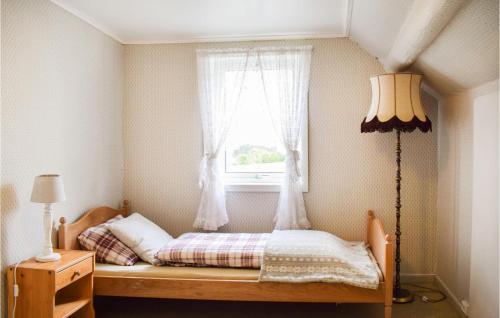 a small bedroom with a bed with a window at Beautiful Home In Sveio With Wifi in Kvalvåg