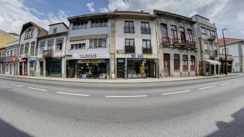 a building on a street with an empty road at We Are Hostel 2 in Póvoa de Varzim