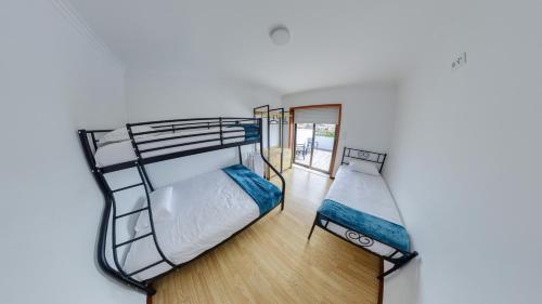 two bunk beds in a room with a window at We Are Hostel 2 in Póvoa de Varzim