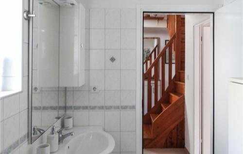 ein Badezimmer mit einem Waschbecken, einem Spiegel und einer Treppe in der Unterkunft Awesome Apartment In Unije With Wifi in Unije