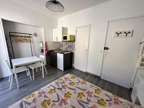 ein kleines Zimmer mit einem Tisch und einer Küche in der Unterkunft Studios climatisés proche mer in Nizza