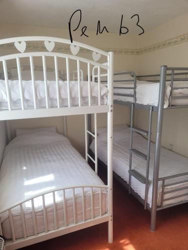 two white bunk beds in a room with a sign that reads raspberry at 63 Bermuda in Hemsby