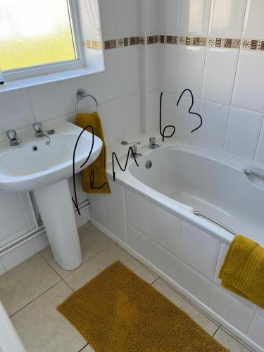 a bathroom with a white tub and a sink at 63 Bermuda in Hemsby