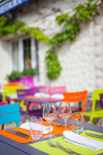 a table with four wine glasses on top of it at Hôtel SPA du Lac de Madine - Maison DRAPIER in Heudicourt-sous-les-Côtes