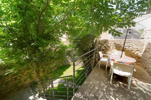 a patio with a table and chairs on a balcony at La Petite Maison du Périgord in Tourtoirac