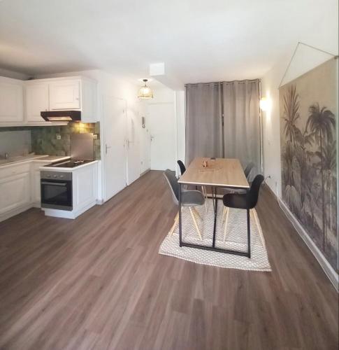 uma sala de estar com uma mesa e uma cozinha em Vacances cosy avec piscine 1 à 4 pers dans joli appartement em Sérignan