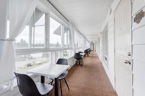 a hallway with tables and chairs and windows at Auberge Hotel Spa Watel in Sainte-Agathe-des-Monts