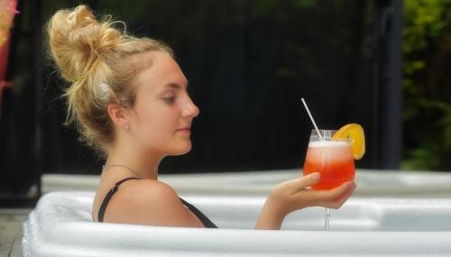 a woman sitting in a chair holding a drink at Auberge Hotel Spa Watel in Sainte-Agathe-des-Monts