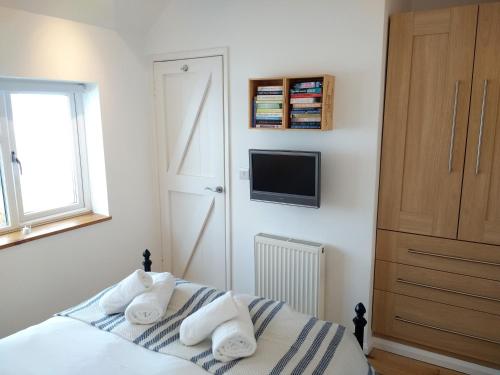 1 dormitorio con 1 cama con toallas en Luxury detached annexe in Kingsbridge with estuary walk to great pub & parking en Kingsbridge