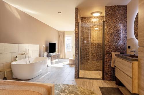 a large bathroom with a tub and a shower at Het Oude Stadhuis in Enschede