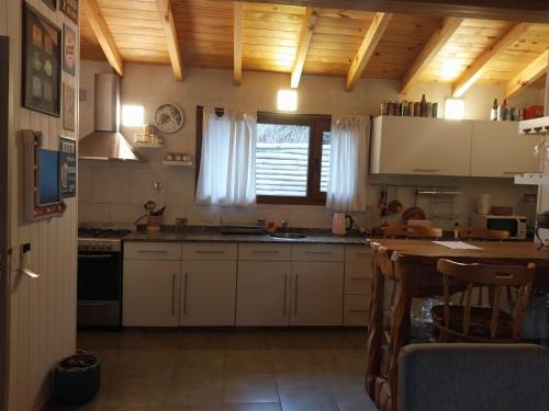 cocina con armarios blancos y techo de madera en Reina Mora, Reserva Patagonica en San Martín de los Andes