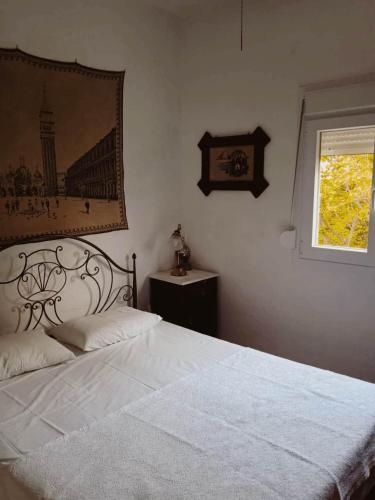 a bedroom with a white bed and a window at Kosta's Cozy Home in Asprovalta