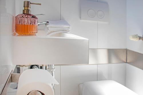 a white bathroom with a toilet and a sink at BlackNCozy - Stellwerk mit Boxspringbett in zentraler Lage in Lörrach
