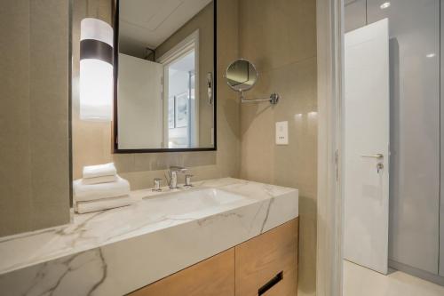 a bathroom with a sink and a mirror at Nasma Luxury Stays - Fantastic Summer Getaway, Steps From The Beach in Fujairah