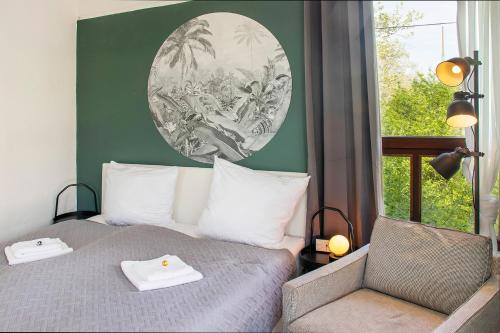 a bedroom with a bed with a chair and a picture on the wall at Historisches Stellwerk mit Garten in bester Innenstadtlage & Boxspringbetten nahe der Schweizer Grenze in Lörrach