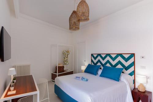 a bedroom with a white bed with blue pillows at Relais del Mare in Sorrento