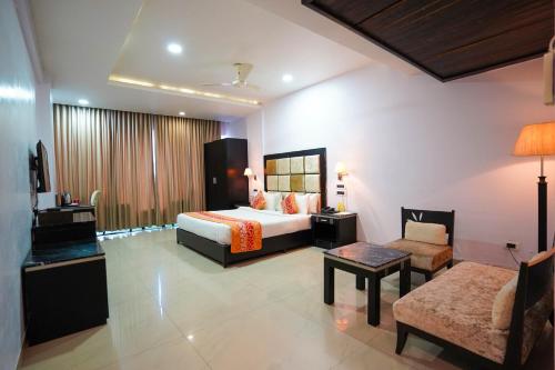 a hotel room with a bed and a living room at Hotel Floret Inn in Bhilai