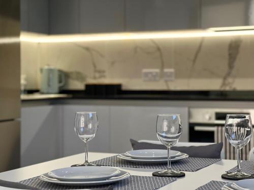 drie wijnglazen zittend op een tafel in een keuken bij Spacious 1 Bed Apartment With Ocean View Balcony in Gibraltar
