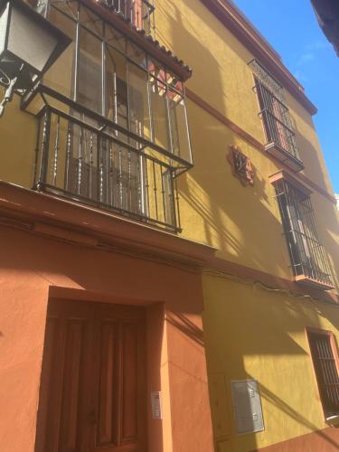 een geel gebouw met een balkon en een deur bij MORATIN in Sevilla