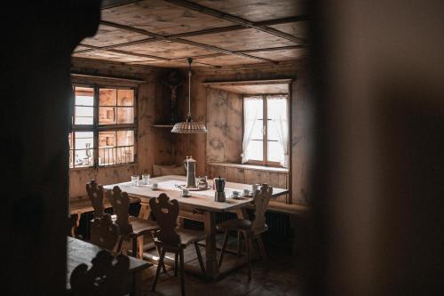 ein Esszimmer mit einem Tisch, Stühlen und Fenstern in der Unterkunft Felder Alpin Lodge in Villanders