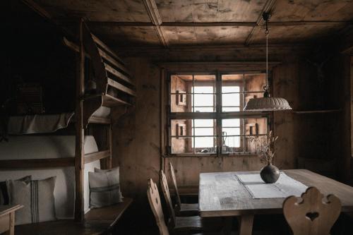 ein Esszimmer mit einem Tisch und einem Fenster in der Unterkunft Felder Alpin Lodge in Villanders