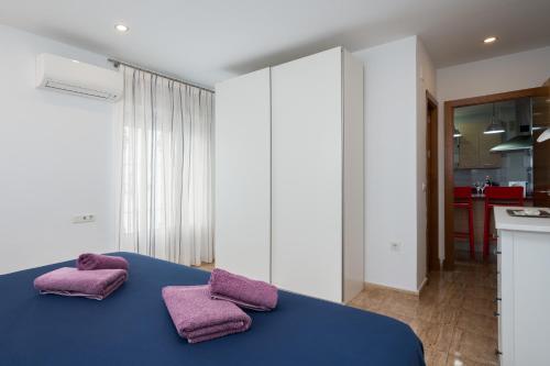 una camera con 2 cuscini viola su un letto blu di Ático Plata a Cadice