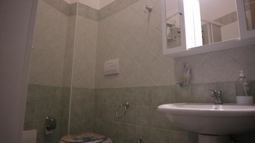 y baño con lavabo, aseo y espejo. en Rocca Cilento B&B, en San Martino