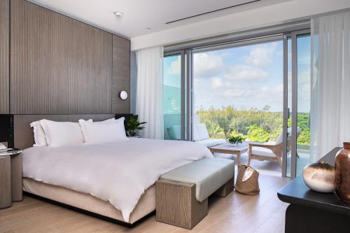 a bedroom with a large bed and a large window at Goldwynn Resort & Residences in Nassau