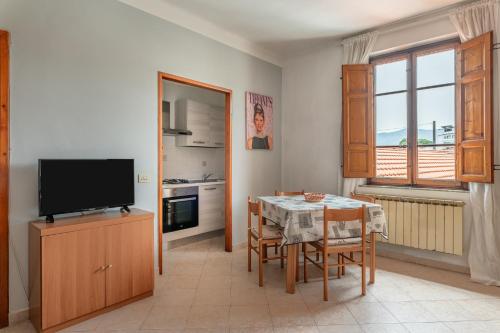 a kitchen and dining room with a table and a television at Apartments Volpino - Affitti Brevi Italia in Lucca