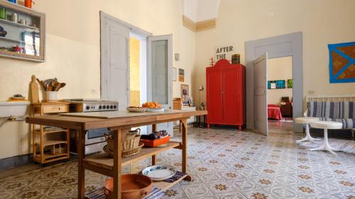 een keuken met een tafel en een rode koelkast bij Italianway - Dammuso San Cesario in San Cesario di Lecce