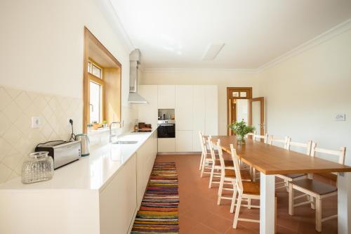 a kitchen with a long wooden table and chairs at Countryside Villa with Nature & Pool - 'Casa dos Vasconcelos' in Chaves