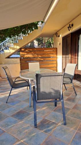 two chairs and a table on a patio at Βlueview in Ermioni