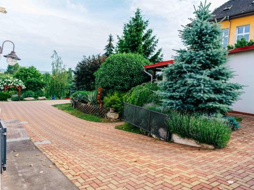 a brick driveway with a christmas tree in a yard at Penzion Labská Vyhlídka in Litoměřice