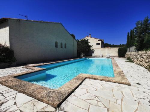 a swimming pool in a yard next to a building at L'Authentique - Villa Piscine Privative WIFI in Saint-Mitre-les-Remparts