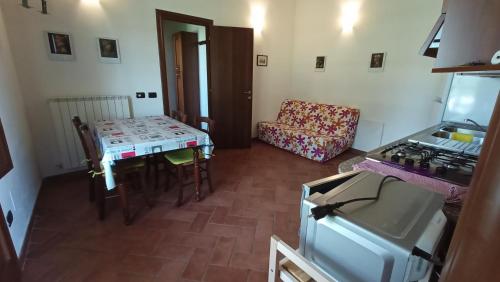 a living room with a table and a kitchen with a stove at il Chiassetto Agriturismo No Kids in Cascina