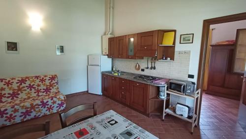 a small kitchen with wooden cabinets and a counter top at il Chiassetto Agriturismo No Kids in Cascina